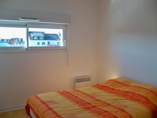 une chambre avec un lit et une fenêtre dans l'établissement Appartement moderne 3 pièces avec balcon, ascenseur, proche plages et commerces, parking inclus - FR-1-349-64, à Ploemeur