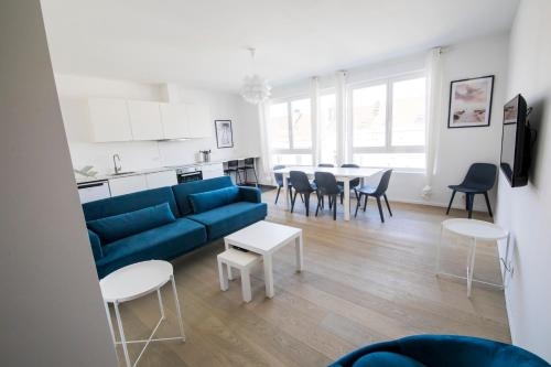 a living room with a blue couch and a table at Smart Appart - Clmenceau in Brussels