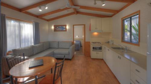 eine Küche und ein Wohnzimmer mit einem Sofa und einem Tisch in der Unterkunft Moama Riverside Holiday Park in Moama