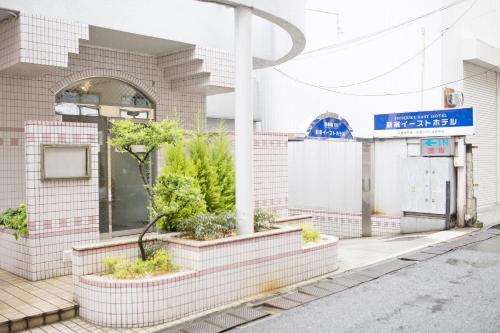 a building with plants on the side of a street at Shinjuku East Hotel in Tokyo