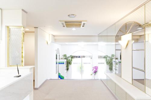 a hallway with white walls and a glass wall at Shinjuku East Hotel in Tokyo