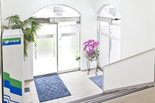 a front door of a building with purple flowers at Shinjuku East Hotel in Tokyo