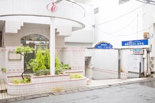 a building with plants in pots on the street at Shinjuku East Hotel in Tokyo