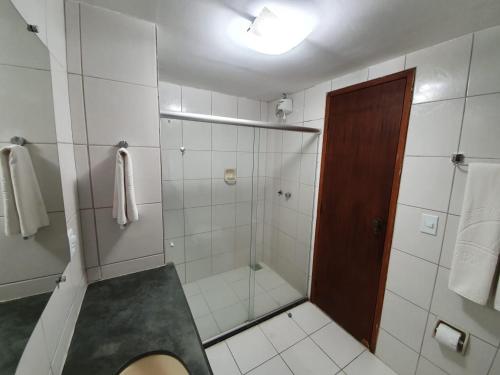 uma casa de banho com um chuveiro e um lavatório. em Apartamento Porto Bello Park by Decolando Turismo em Porto Seguro