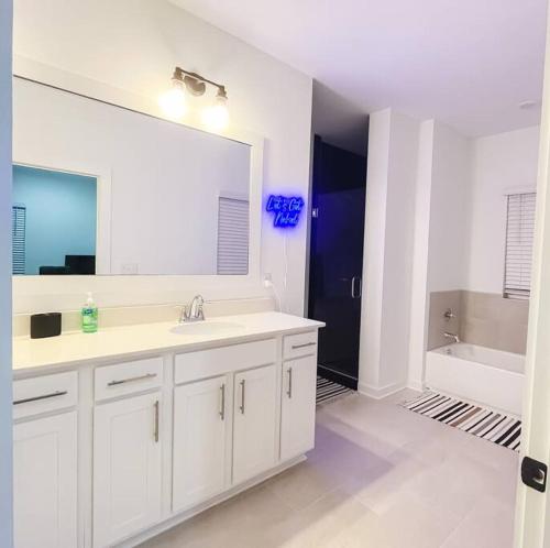 a bathroom with a sink and a large mirror at 5 Star 4/3 sleeps 16 with Arcade GAME ROOM & POOL! in Orange Beach