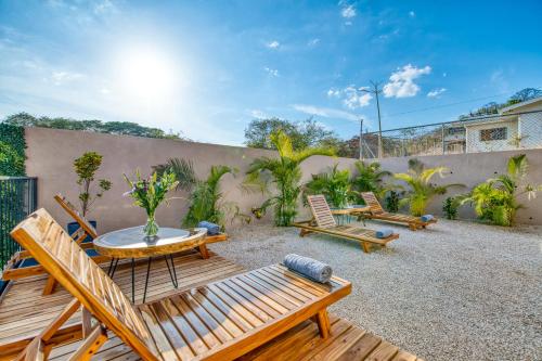 a patio with chairs and a table and a fence at Muna Tamarindo in Tamarindo