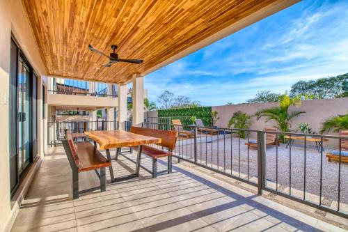 a deck with a table and chairs on a balcony at Muna Tamarindo in Tamarindo