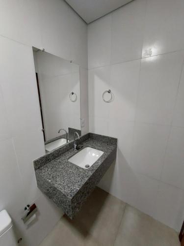 y baño con lavabo y espejo. en Linda casa na cidade de Chapada dos Guimarães/MT., en Chapada dos Guimarães