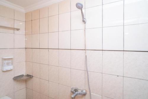 eine Dusche mit Duschkopf im Bad in der Unterkunft Sabar Mansion 22 Mitra RedDoorz in Jakarta