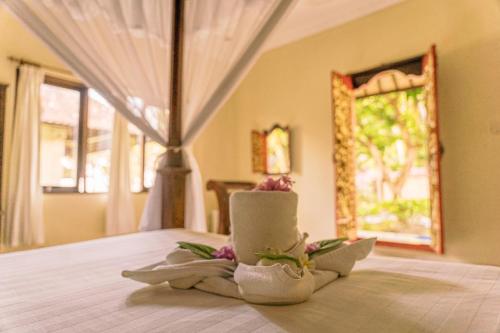 Cette chambre comprend un lit avec des serviettes et une fenêtre. dans l'établissement Coral Bay Bungalows Amed Bali, à Amed