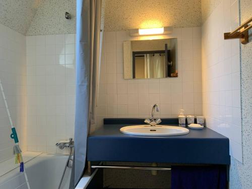 La salle de bains est pourvue d'un lavabo, d'un miroir et d'une baignoire. dans l'établissement Maison Pleumeur-Bodou, 1 pièce, 4 personnes - FR-1-368-395, à Pleumeur-Bodou