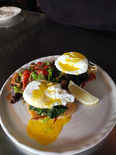 een bord met eieren en groenten op tafel bij FULLMOON CANGGU Nelayan in Canggu