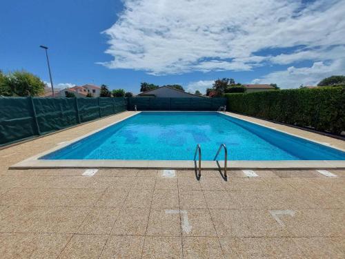 une grande piscine bleue avec des pinces dans une cour dans l'établissement Charmante maisonnette avec piscine, proche plage et centre-ville - Vaux-sur-Mer - FR-1-550-68, à Vaux-sur-Mer