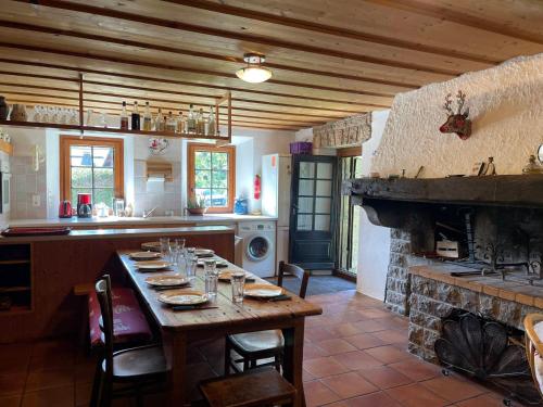 une cuisine avec une table en bois et une cheminée dans l'établissement Chalet cosy avec cheminée et grand jardin, proche du télécabine de Vercland à Samoëns - FR-1-624-134, à Samoëns