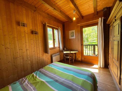 une chambre avec un lit dans une pièce avec une fenêtre dans l'établissement Chalet cosy avec cheminée et grand jardin, proche du télécabine de Vercland à Samoëns - FR-1-624-134, à Samoëns