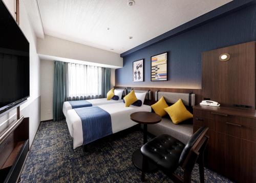 神戶的住宿－神戶三宮方丹別墅酒店，一间酒店客房,配有一张床和一台电视