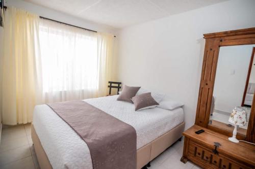 a bedroom with a large bed and a window at CASA SANTA CIRCASIA in Circasia