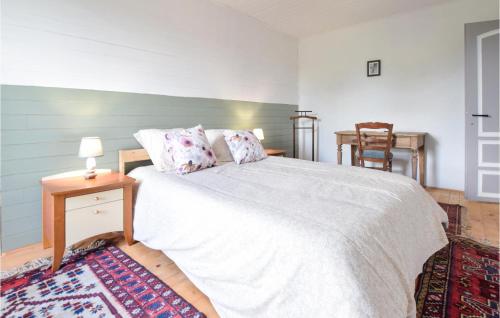 a bedroom with a white bed with a table and a chair at 3 Bedroom Amazing Home In Carrouges in Carrouges