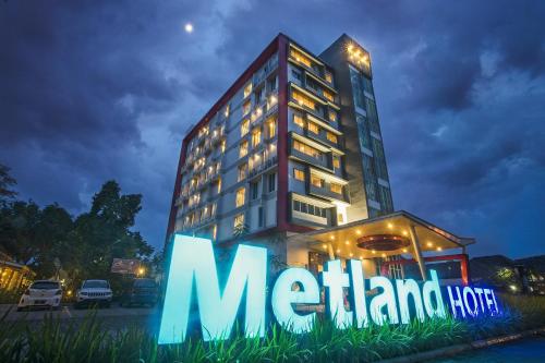 un gran edificio con un cartel delante en Metland Hotel Cirebon by Horison en Cirebon