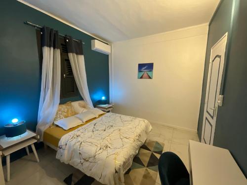 Un dormitorio con una cama con luces azules. en Résidence Peace & Joy en Fort-de-France