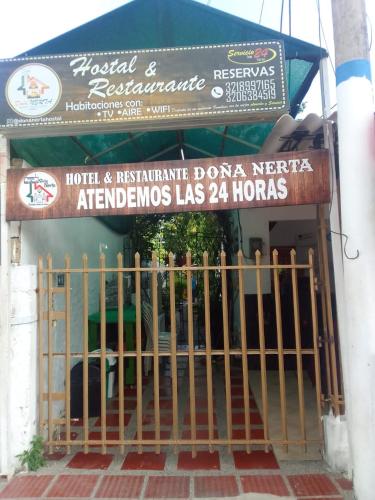 Hotel & Restaurante Doña Nerta bosque في كارتاهينا دي اندياس: بوابة امام مبنى عليه لافته