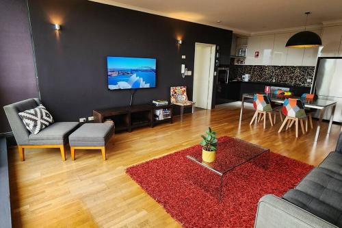 Contemporary Top Floor Apartment في سيدني: غرفة معيشة مع أريكة وطاولة