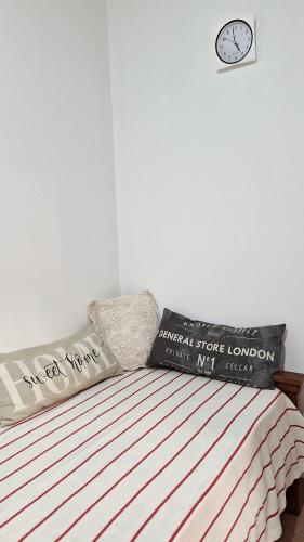 a bedroom with a bed and a clock on the wall at Departamento Vela Céntrico in Concepción