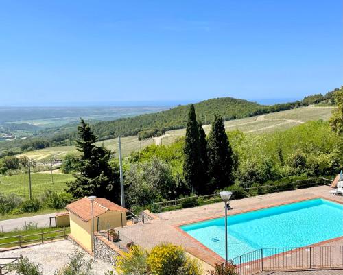 a swimming pool with a view of a hill at Casa Lisa Poggio di Nocola Riparbella by ToscanaTour in Podere Dottrina
