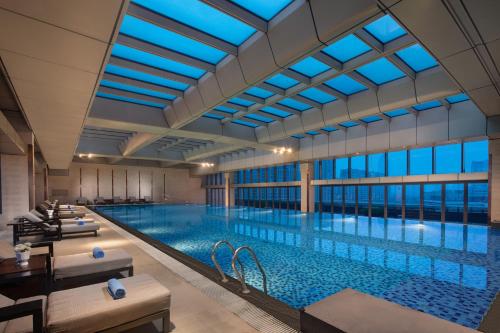 a large swimming pool with a large ceiling at Pullman Haining in Haining