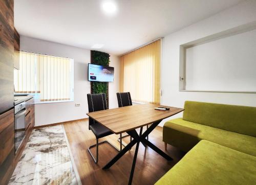 a living room with a table and a green couch at Sun-kissed Varna Getaway in Varna City