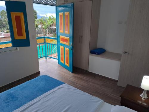 a bedroom with a bed and a door with a balcony at APARTAHOTEL DON BELI in Salento