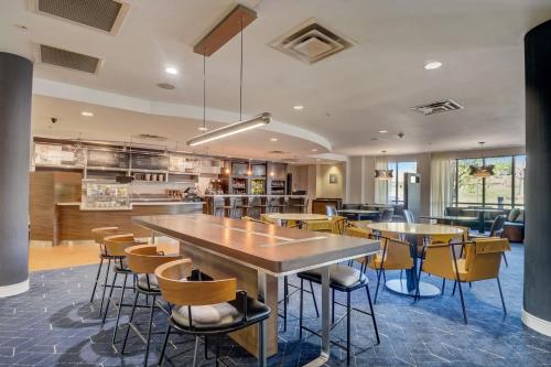 a restaurant with tables and chairs in a room at Courtyard Cincinnati North at Union Centre in West Chester
