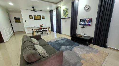uma sala de estar com um sofá e uma sala de jantar em D'Lisha Homestay Changlun/Bukit Kayu Hitam/Sintok em Changlun