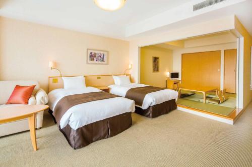 a hotel room with two beds and a couch at Hotel Emion Tokyo Bay in Urayasu