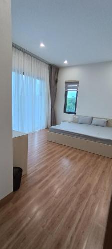 a large room with a bed and a window at Đồi Chè Hotel in Mộc Châu