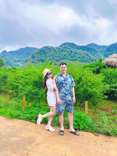 a man and a woman standing on a dirt road at Đồi Chè Hotel in Mộc Châu