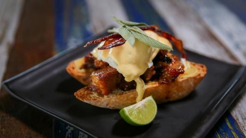 a black plate with a sandwich with cheese and a lime at Lime N Soda Beachfront Resort in Thongsala