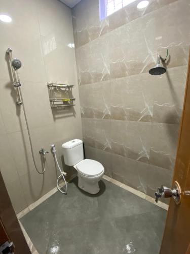 Umyas Hotel Syariah في Nganjuk: حمام مع مرحاض ومقصورة دش