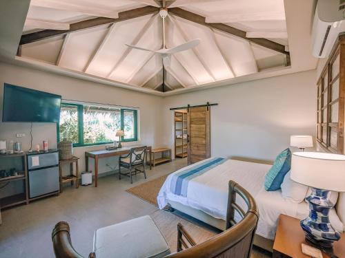 um quarto com uma cama, uma mesa e cadeiras em Kaimana Resort Siargao em General Luna