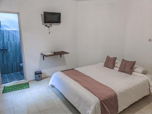 a bedroom with a large bed and a television at Rumah Ceria near Bandara Ahmad Yani Semarang RedPartner in Kalibanteng-lor