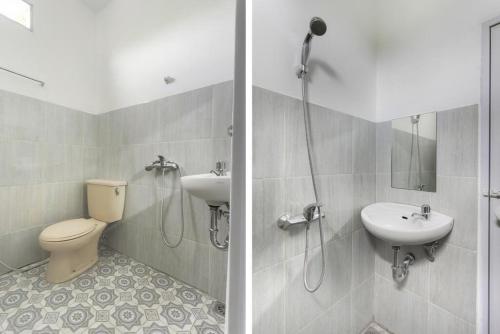 a bathroom with a toilet and a sink and a shower at Rumah Ceria near Bandara Ahmad Yani Semarang RedPartner in Kalibanteng-lor