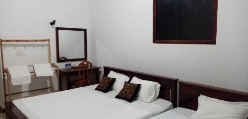 a bedroom with a bed with two pillows and a mirror at Jungle Edge Home Sigiriya in Sigiriya