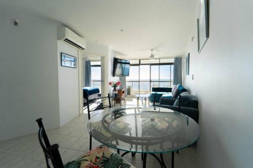a living room with a glass table in a room at Spectacular Central Surfers Beach Views from Apartment in Gold Coast
