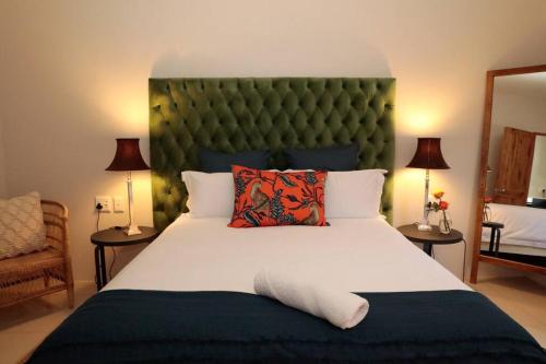 a bedroom with a large bed with a green headboard at Gorgeous 1-bedroom Sandton flat in Johannesburg