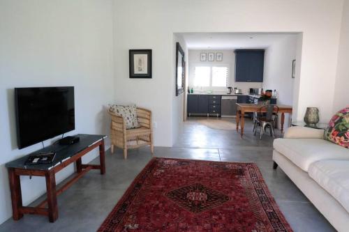 sala de estar con sofá y TV en Gorgeous 1-bedroom Sandton flat, en Johannesburgo