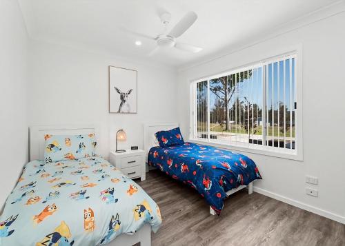 a bedroom with a bed and a window at Marie's Rest in Tomakin