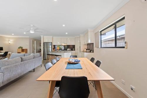 a kitchen and living room with a wooden table and chairs at Tides at Tomakin in Tomakin