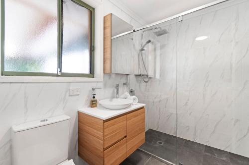 une salle de bain avec toilettes, lavabo et douche dans l'établissement Teds at Broulee, à Broulee