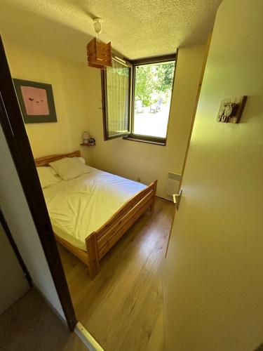 a small bedroom with a bed and a window at Superbe appartement tout équiper in Lélex