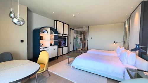 a bedroom with a bed and a table and a dining room at New World Hoiana Beach Resort in Hoi An